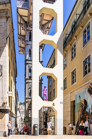 The structure behind the purple girl is the Santa Justa lift- an elevator that is the fastest way to